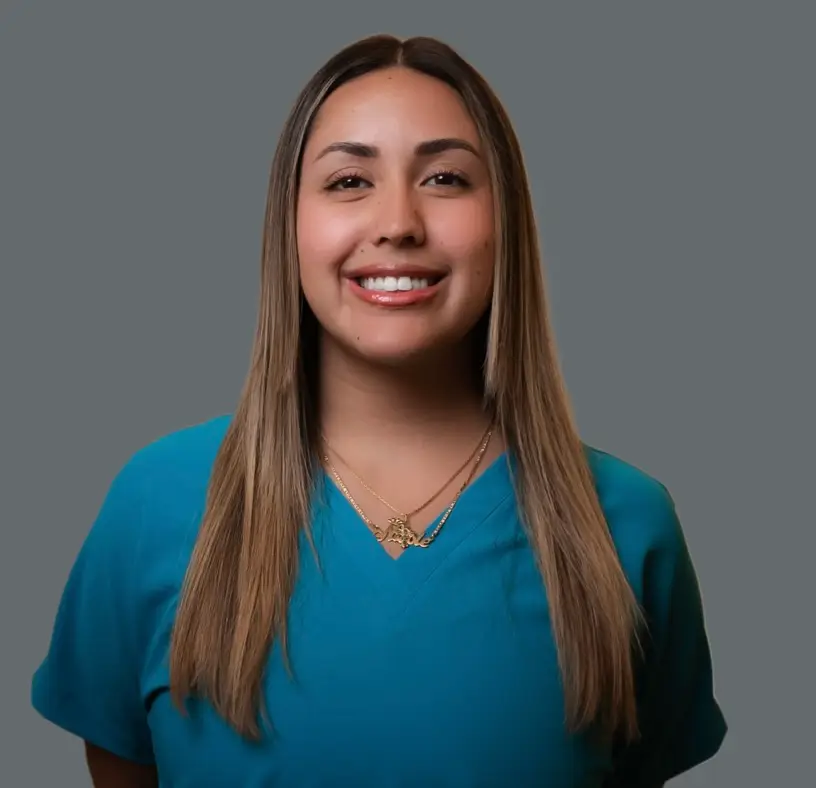 Nicole Puerta, Patient Concierge at SP Aesthetics, smiling in teal scrubs, showcasing her dedication to customer service and beauty expertise.